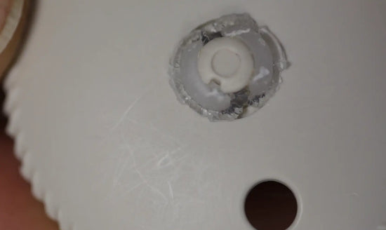Close-up of pacifier shield showing visible scrape marks and a damaged nipple base with bite impressions.
